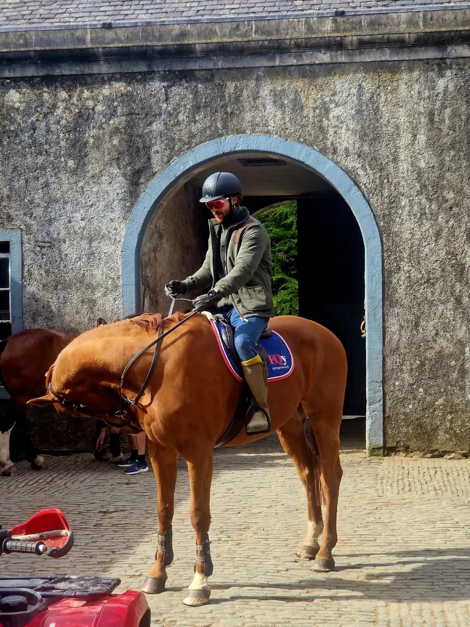 A rider under the arch of the Category A listed stable court